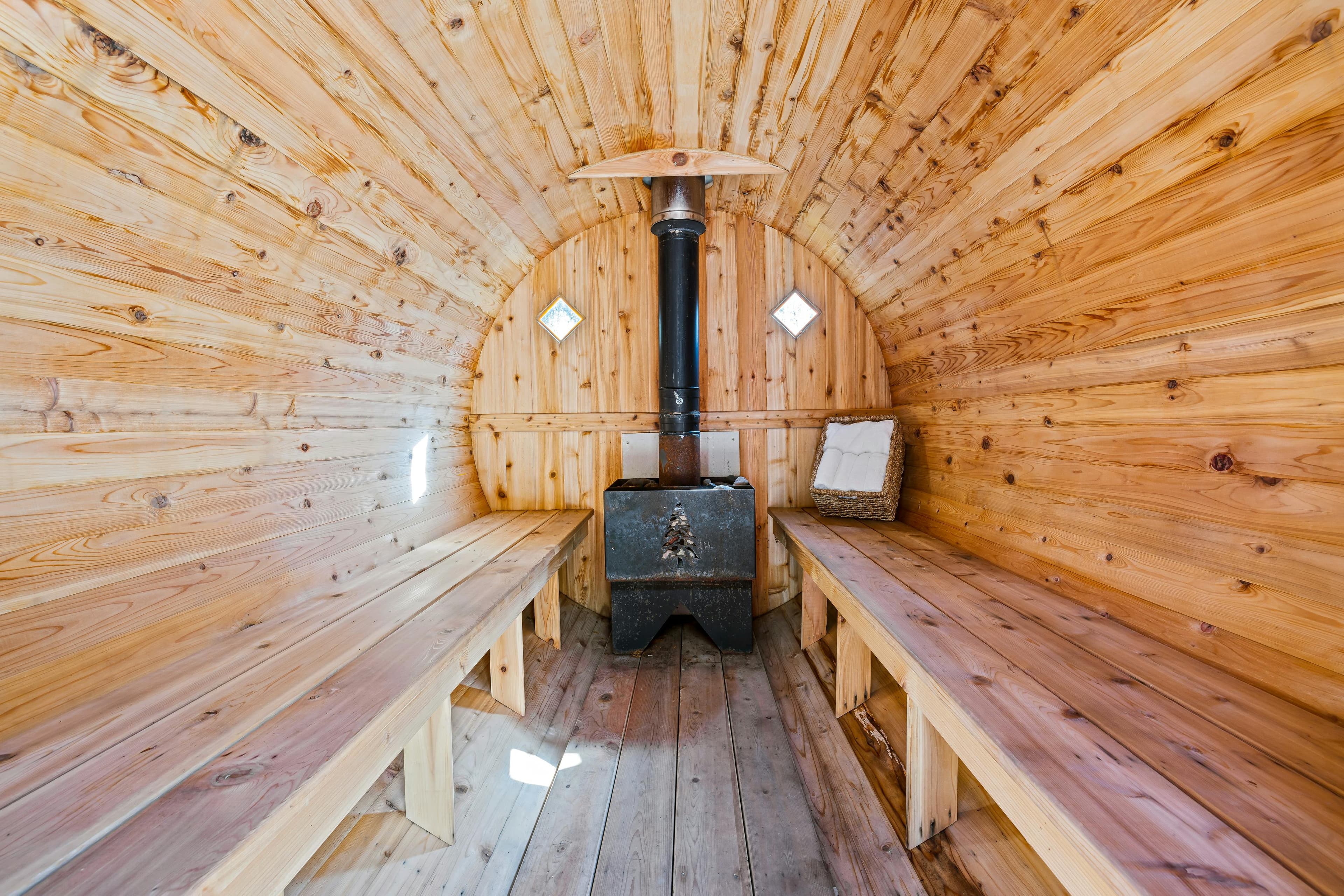 Wood-fired sauna interior with stove and benches